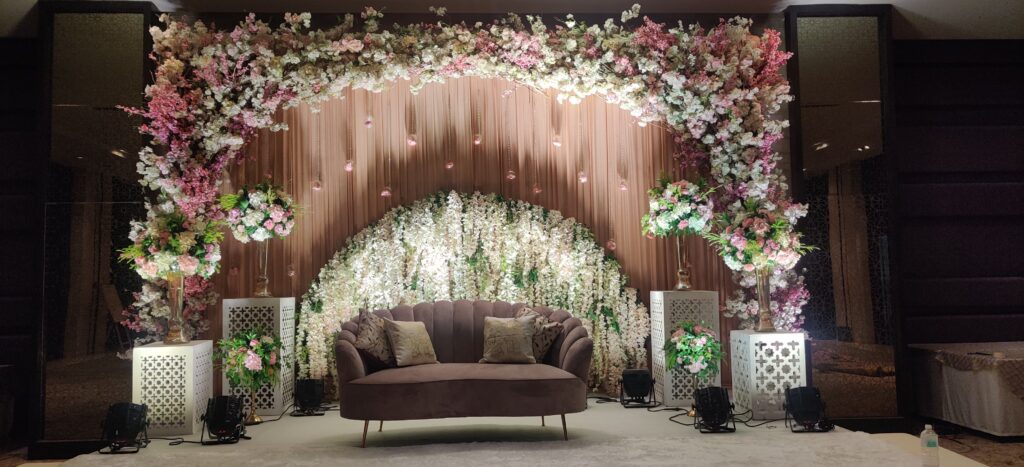A beautifully decorated wedding stage in Delhi, featuring vibrant flowers and elegant chairs for guests.
